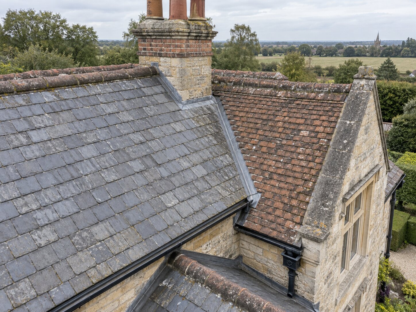 Close aerial inspection view of roof coverings and chimney details
